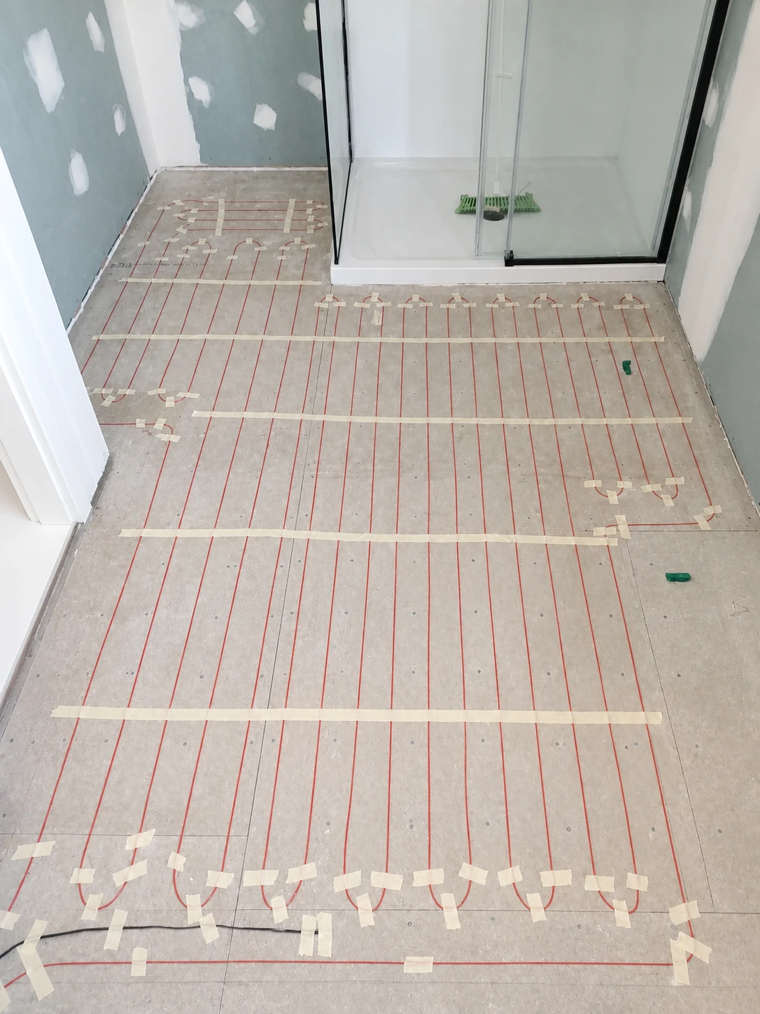 Neatly installed underfloor heating mat beneath bathroom tiles